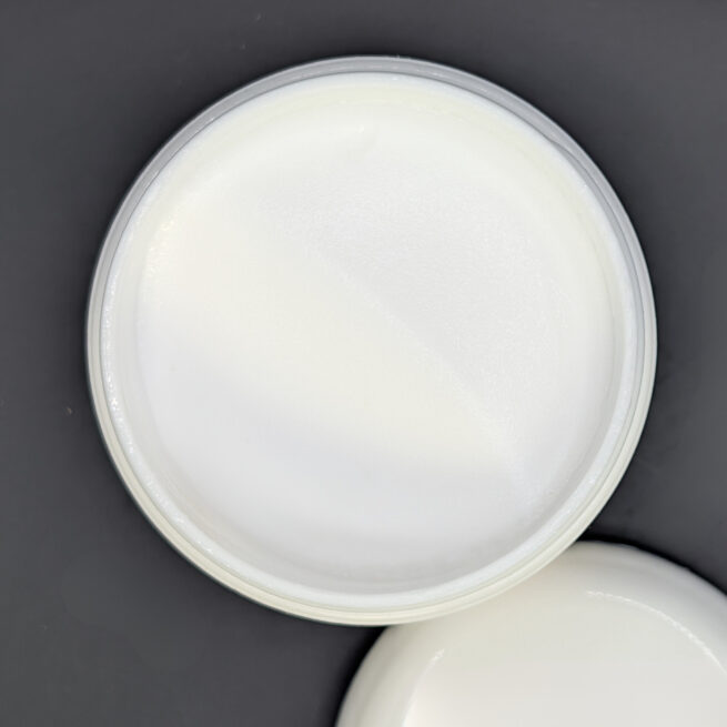 Picture of body cream against a black background